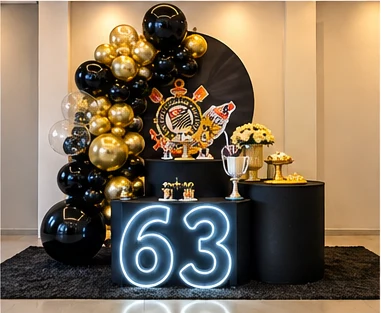 Decoração de 63 anos em preto e dourado com número em neon