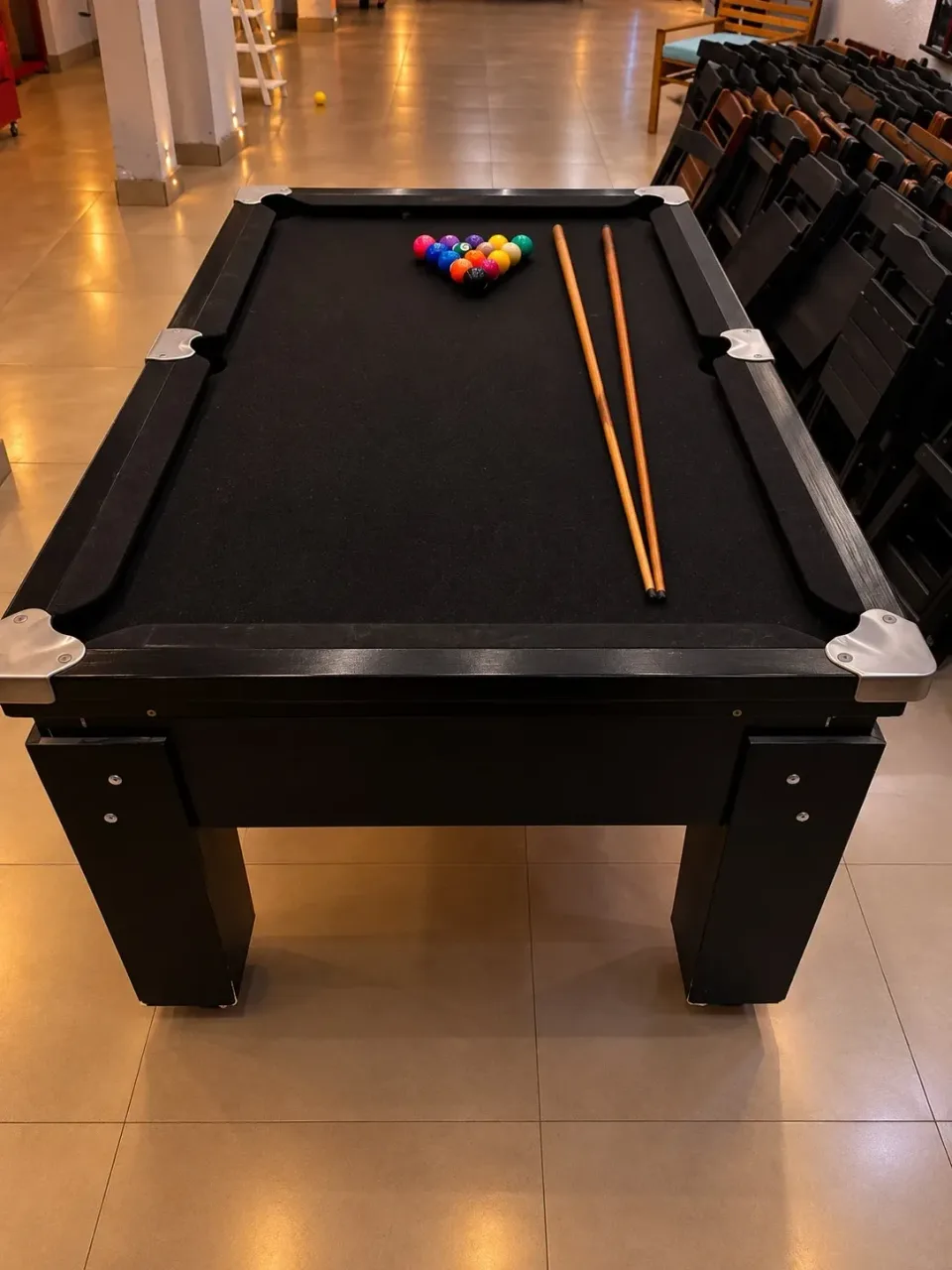 Mesa de sinuca no salão iluminado à noite